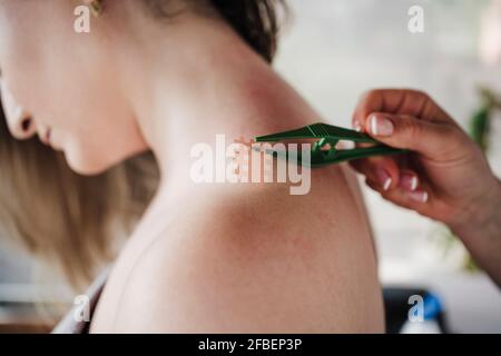 Therapeutin klebt im Krankenhaus ein elastisches Kreuzband an den Patienten Stockfoto