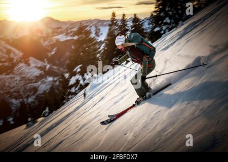 Frau mit mittlerem Erwachsenenalter, die im Winter auf einem verschneiten Berg Ski fährt Stockfoto