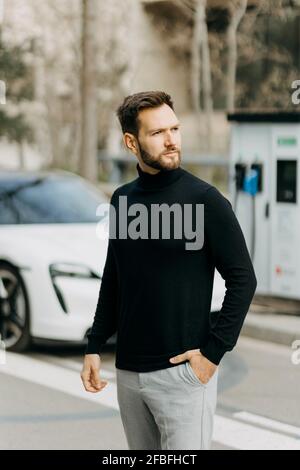 Ein hübscher Mann, der auf der Straße steht und wegschaut Stockfoto