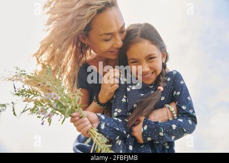 Glückliche Mutter und Tochter mit Blumenstrauß Stockfoto