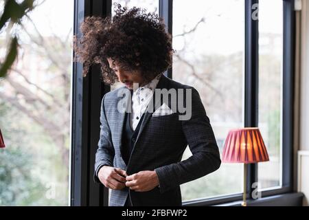 Der junge Geschäftsmann knöpfte im Café den Anzug Stockfoto