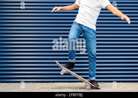 Junger Mann übt Stunt auf dem Skateboard Stockfoto