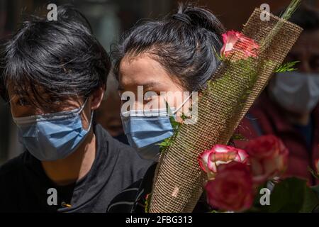 Barcelona, Spanien. April 2021. Ein junges japanisches Paar wird in einem der traditionellen Blumenläden auf Las Ramblas in Barcelona rote Rosen kaufen sehen. Trotz der Kapazitätskontrolle und Distanzierungsmaßnahmen aufgrund der Covid-Pandemie, gewinnt Barcelona erfolgreich das Fest von Sant Jordi, dem schutzpatron von Katalonien, Mit dem traditionellen Tag des Verkaufs von Büchern und Rosen. Kredit: SOPA Images Limited/Alamy Live Nachrichten Stockfoto