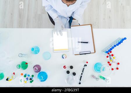 Forscher, die im Labor an einem digitalen Tablet auf dem Tisch arbeiten Stockfoto