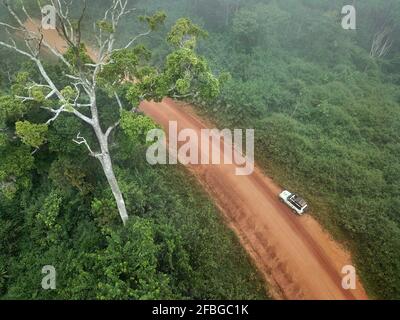 Gabun, Mikongo, Luftaufnahme eines 4x4-Autos, das auf einer unbefestigten Straße mitten im Dschungel geparkt ist Stockfoto