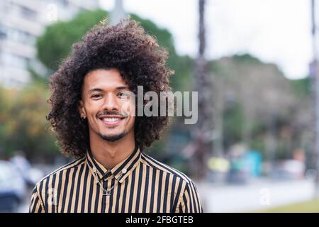 Junger Mann im gestreiften Hemd mit lockigen Haaren Stockfoto