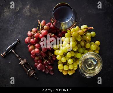 Studio Schuss von frischen Trauben, Korkenzieher und zwei Glas rot und Weißwein Stockfoto