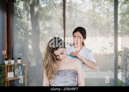 Physiotherapeutin, die elastisches therapeutisches Band auf die Schulter des Patienten aufklebt Krankenhaus Stockfoto