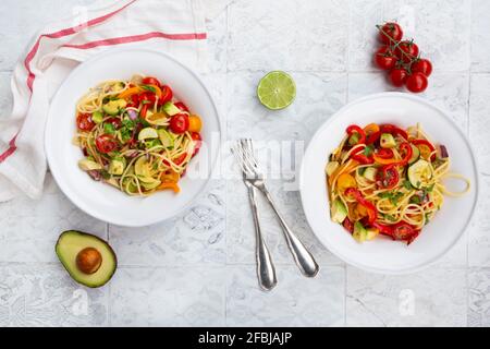 Spaghetti mit gegrilltem Gemüse, Paprika, Zucchini, Avocado, Tomaten und Koriander Stockfoto