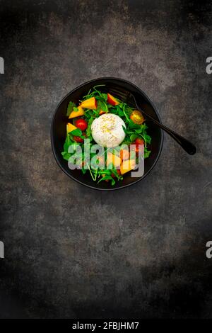 Salat aus Rucola, Nektarine, Tomaten, Zitronenmelisse, Basilikum und Burrata Stockfoto
