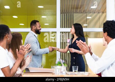 Kollegen klatschen für Unternehmer, die bei einem Treffen im Büro Handshake machen Stockfoto