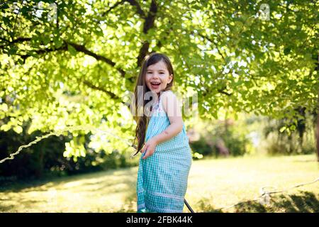 Fröhliches Mädchen mit Pfeife im Garten Stockfoto