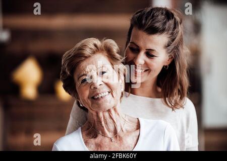 Lächelnde junge Frau, die die glückliche Großmutter anschaut Stockfoto