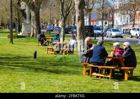 Menschen, die draußen auf Bänken an der Hauptstraße sitzen, tenterden, kent, großbritannien Stockfoto