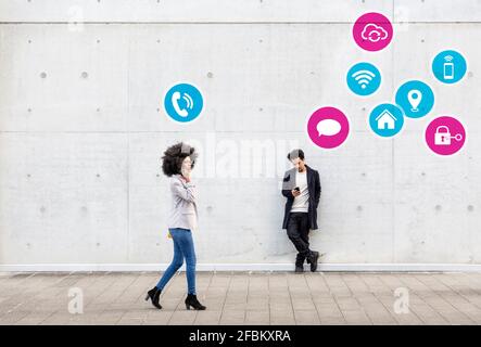 Geschäftsfrau, die auf dem Mobiltelefon mit einem Mann im Hintergrund spricht Mit Symbol auf Fußpfad gesetzt Stockfoto