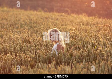 Mädchen mit blonden Haaren beobachten Pflanze Stockfoto