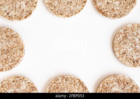 Knusprige Reiskuchen isoliert auf weißem Hintergrund, Rahmen aus gepufftem Vollkorn-Knäckebrot und leerer Platz für Text, Nahaufnahme Stockfoto