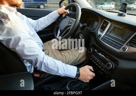 Die Uhr auf dem Armaturenbrett eines teuren Auto ist Close-up, mit  natürlichen Beige Leder überzogen, mit weißem Zifferblatt, ein roter Pfeil  und ein Metall chrom Felge Stockfotografie - Alamy