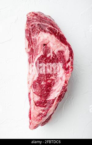 RAW Rib Eye Beef Steak aus marmoriertem Fleisch, komplett geschnitten, auf weißem Stein Hintergrund, Draufsicht flach liegend Stockfoto