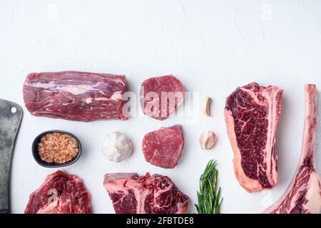 Verschiedene Schnitte von marmoriertem Rindfleisch und trocken gereiften Steaks Set, Tomahawk, t bone, Club Steak, Rib Eye und Filet Schnitte, auf weißem Stein Hintergrund, oben V Stockfoto