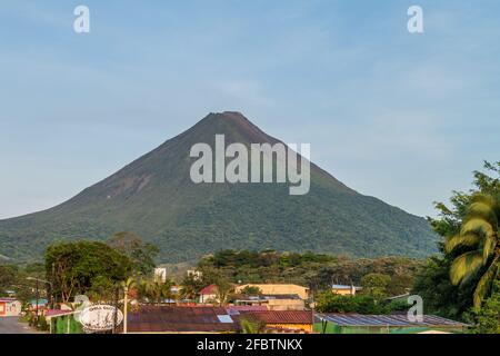 LA FORTUNA, COSTA RICA - 8. MAI 2016: Der Vulkan Arenal ragt hinter dem Dorf La Fortuna hoch. Stockfoto