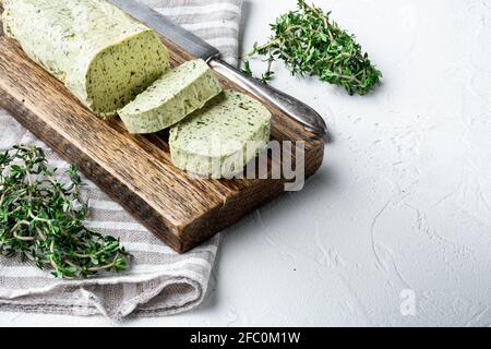 Portion Kräuterbutter mit Schnittlauch, Basilikum, Oregano, Petersilie-Set, auf weißem Stein-Hintergrund, mit Platz für Text Stockfoto