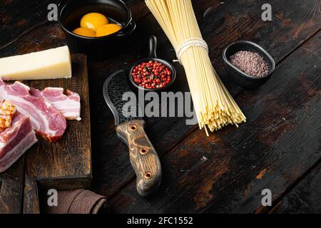 Traditionelle Italienische Pasta Carbonara Zutaten. Speck, Spaghetti, Parmesan und Pecorino Käse, Ei, Knoblauch-Set, auf altem dunklen Holztisch, mit Kopie Stockfoto