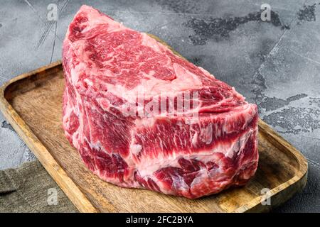 RAW Rib Eye Beef Steak aus marmoriertem Fleisch, komplett geschnitten, auf grauem Stein Hintergrund Stockfoto