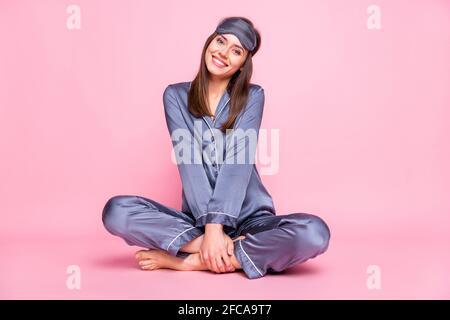 In voller Länge Foto-Porträt von niedlichen Mädchen im Lotus sitzen Pose isoliert auf pastellrosa Hintergrund Stockfoto