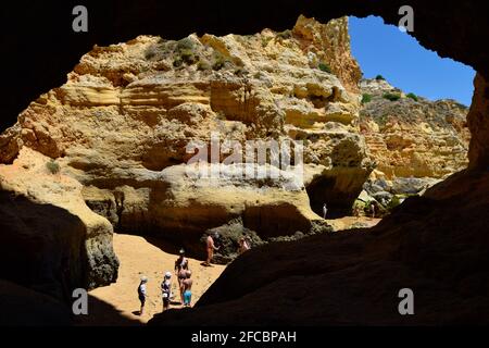 Leute, die den Strand von Praia da Marinha, Marinha Strand an der Algarve Portugal im Sommer genießen, mit wunderschönem Meer- und Bergblick Stockfoto