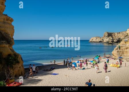 Menschen am Strand genießen den Sommer an der Algarve Marinha Beach im Süden Portugals. Schöner Strand in Portugal voller Menschen und Familien. Stockfoto