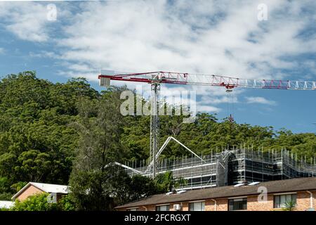 März 30. 2021. Turmkrane- und Betonboom-Pumpe, die auf einer neuen Baustelle mit Buschland-Hintergrund betrieben wird. Gosford, Australien. Stockfoto