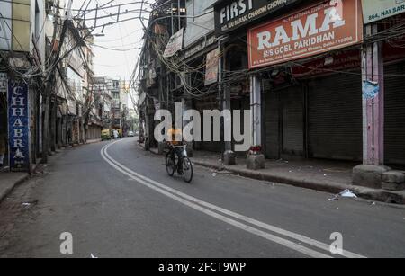 Neu-Delhi, Indien. April 2021. Ein Radfahrer fährt während der von der Regierung von Delhi verhängten Wochenendsperre an einem geschlossenen Markt vorbei, um die Ausbreitung der Coronavirus-Krankheit einzudämmen. Indien geht während der zweiten Welle der Covid-19-Pandemie der Sauerstoff aus. Indien verzeichnete an einem einzigen Tag 332,730 neue Covid-19-Fälle und 2,263 Todesfälle an einem letzten Tag. Kredit: SOPA Images Limited/Alamy Live Nachrichten Stockfoto