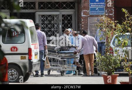 Neu-Delhi, Indien. April 2021. Verwandte helfen einem mutmaßlichen Covid-19-Patienten, der im Krankenhaus Lok Nayak Jai Prakash (LNJP) in Alt-Delhi eingeliefert wurde. Indien geht während der zweiten Welle der Covid-19-Pandemie der Sauerstoff aus. Indien verzeichnete an einem einzigen Tag 332,730 neue Covid-19-Fälle und 2,263 Todesfälle an einem letzten Tag. (Foto von Naveen Sharma/SOPA Images/Sipa USA) Quelle: SIPA USA/Alamy Live News Stockfoto