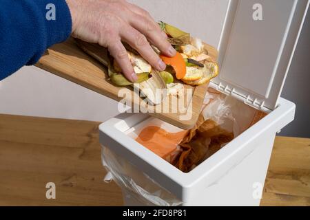 Ein Mann, der den organischen Abfall in den Papierkorb wirft Stockfoto