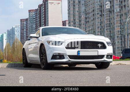 Ukraine, Kiew - 22. April 2021: Weißes Ford Mustang Coupé Auto auf der Straße geparkt. Redaktionell Stockfoto