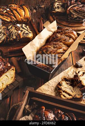 Das Stillleben verschiedener Art des süßen Wirbels des Sauerteiges Brot auf Holzhintergrund Stockfoto