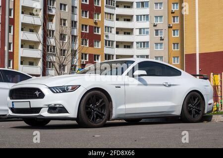 Ukraine, Kiew - 22. April 2021: Weißes Ford Mustang Coupé Auto auf der Straße geparkt. Redaktionell Stockfoto