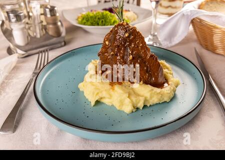 Langsam gekochtes Schweinefleisch serviert mit Kartoffelpüree und bbq-Sauce Stockfoto