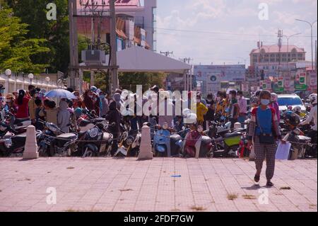 Aufgrund der jüngsten Ausbrüche von COVID - 19 in Bekleidungsfabriken und -Märkten hat die kambodschanische Regierung eine Sperre auferlegt. Die Regierung hat Stueng Meanchey jetzt als „Rote Zone“ bezeichnet, alles wurde geschlossen, Heute hat die Regierung beschlossen, dass jeder in den roten Zonen auf das Virus getestet werden muss. Eine kambodschanische Frau geht weg von einer Virenmassenprüfstelle mit ihrem Papierkram, der bestätigt, dass sie virenfrei ist. Eine Reihe von Kambodschanern hinter ihr warten auf ihren Virustest während der Coronavirus-Pandemie. Stueng Meanchey, Phnom Penh, Kambodscha. April 2021. © Kraig Lieb Stockfoto