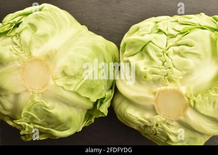 Zwei frische, saftige Bio-Kohl auf einem Servierteller aus Schiefer. Stockfoto