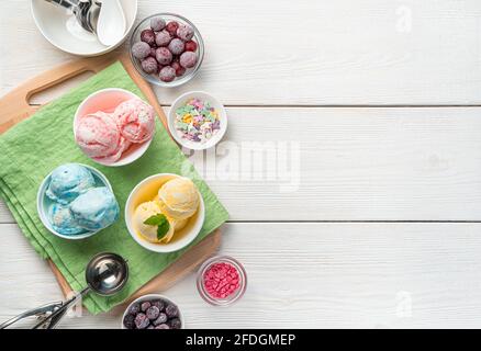 Eis mit Mango-, Himbeer- und Heidelbeergeschmack auf hellem Hintergrund mit Platz zum Kopieren. Ein erfrischendes, fruchtiges Dessert. Stockfoto