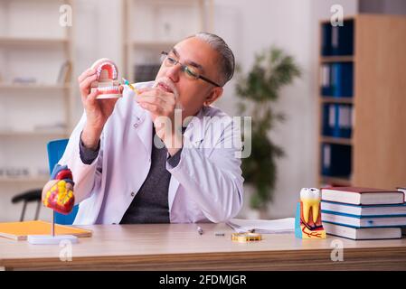 Alte Zahnarztlehrerin sitzt im Klassenzimmer Stockfoto