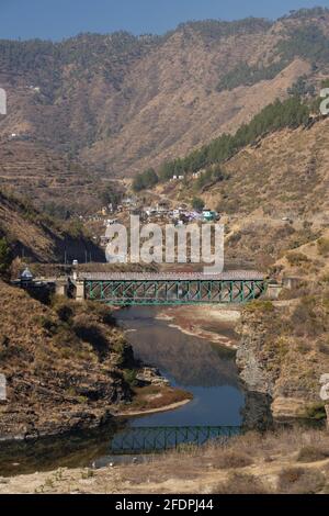 Blick auf einen Fluss, der durch ein enges Tal fließt mit Felsige Berge an den Seiten und eine Brücke oben In der Region Kumaun in Uttara Khand Indien Stockfoto