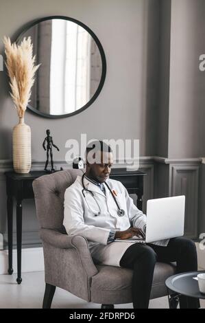 Glücklich positive schwarze Arzt sprechen auf Video-Anruf mit Patienten, lächelnd afroamerikanischen Mann Mitarbeiter haben Online-Gespräch auf Laptop Stockfoto