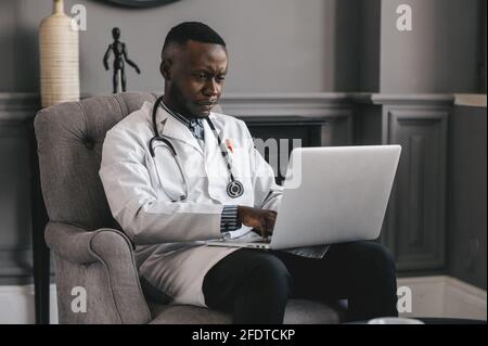 Ein afroamerikanischer Arzt bietet Telemedizin-Konsultationen durch die Übertragung an Medizinische Informationen über Telekommunikationswege Stockfoto