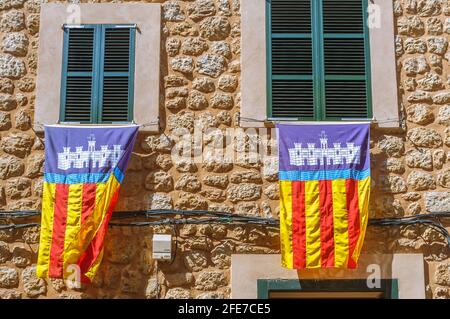 Mallorquinische Flaggen, die während des Es Firo an Fensterrahmen gehängt wurden. Das Fest der Mauren und Christen in der Stadt Soller Mallorca Spanien. Stockfoto