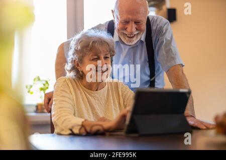 Gerne älteres Paar mit digital-Tablette zu Hause Stockfoto