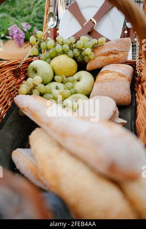 Picknickkorb mit Produkten aus dem Laden frische grüne Äpfel, Trauben und Brot. Stockfoto