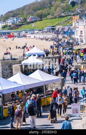 Lyme Regis, Dorset, Großbritannien. April 2021. Wetter in Großbritannien. Massen strömen in den Badeort Lyme Regis, um die warme Sonne und den strahlend blauen Himmel zu genießen. Viele sind in der Stadt, um das Eat Local Food and Drink Festival zu genießen, da die Stadt im Laufe der Jahre wieder normal wird. Eat zielt darauf ab, die besten Lebensmittel- und Getränkehersteller und Kunsthandwerker aus dem West Country in einer gut geführten, sicheren Umgebung im Freien zusammenzubringen. Kredit: Celia McMahon/Alamy Live Nachrichten Stockfoto